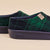 Side close up of Essential Kids slipper in navy and green plaid showing cushioned navy EVA sole and recycled polyester upper