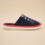 Profile view of Essential slipper in navy terry with red trim, white EVA sole and embroidered AMBER WAVES FARM text on beige background