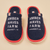 Top-down view of Essential slippers with navy terry upper, red trim, and white embroidered AMBER WAVES FARM text on beige