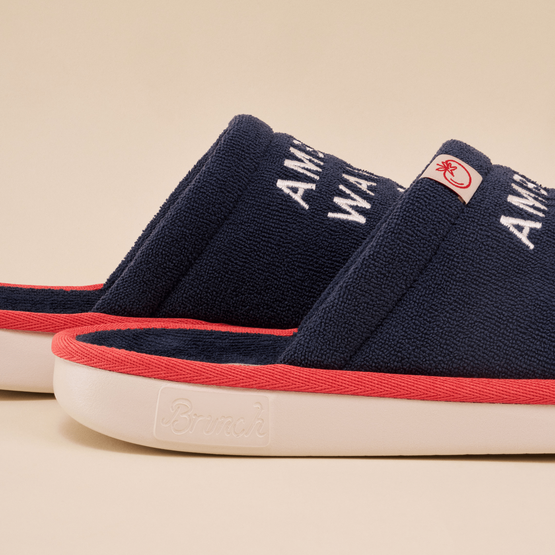 Close-up side view of navy Brunch Essential slipper with Amber Waves embroidery, red trim and embossed Brunch sole