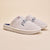 Angled view of pair of Essential Parke Varsity fleece slippers with embroidered PARKE lettering, cushioned white sole on beige