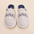 Top-down view of Essential Parke Varsity fleece slippers showing embroidered PARKE lettering and navy terry lining on a beige background