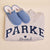 Top view of Essential Parke slipper in vintage denim showing denim upper and shearling on folded gray sweatshirt PARKE logo