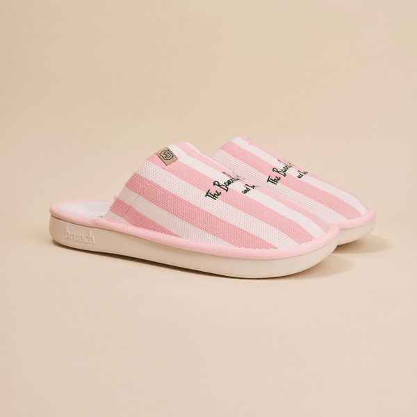 Side view of Essential slipper in pink and white stripes, embroidered Beverly Hills Hotel text, open-back mule with cushioned white sole on beige background