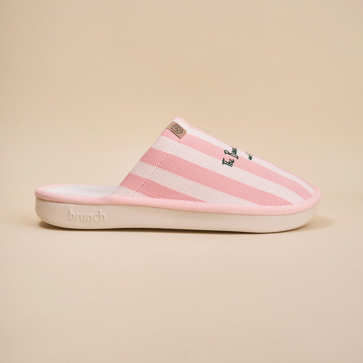 Side view of pink striped Essential slipper with 'Beverly Hills Hotel' embroidery on upper, white sole on beige background