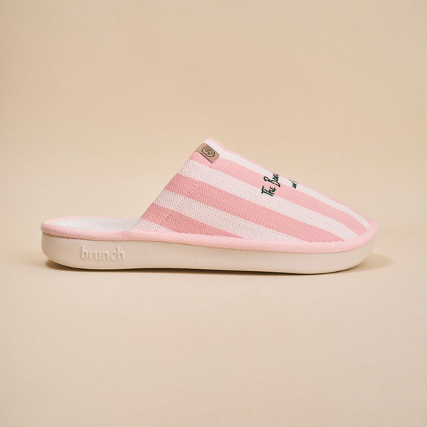 Side view of pink striped Essential slipper with 'Beverly Hills Hotel' embroidery on upper, white sole on beige background