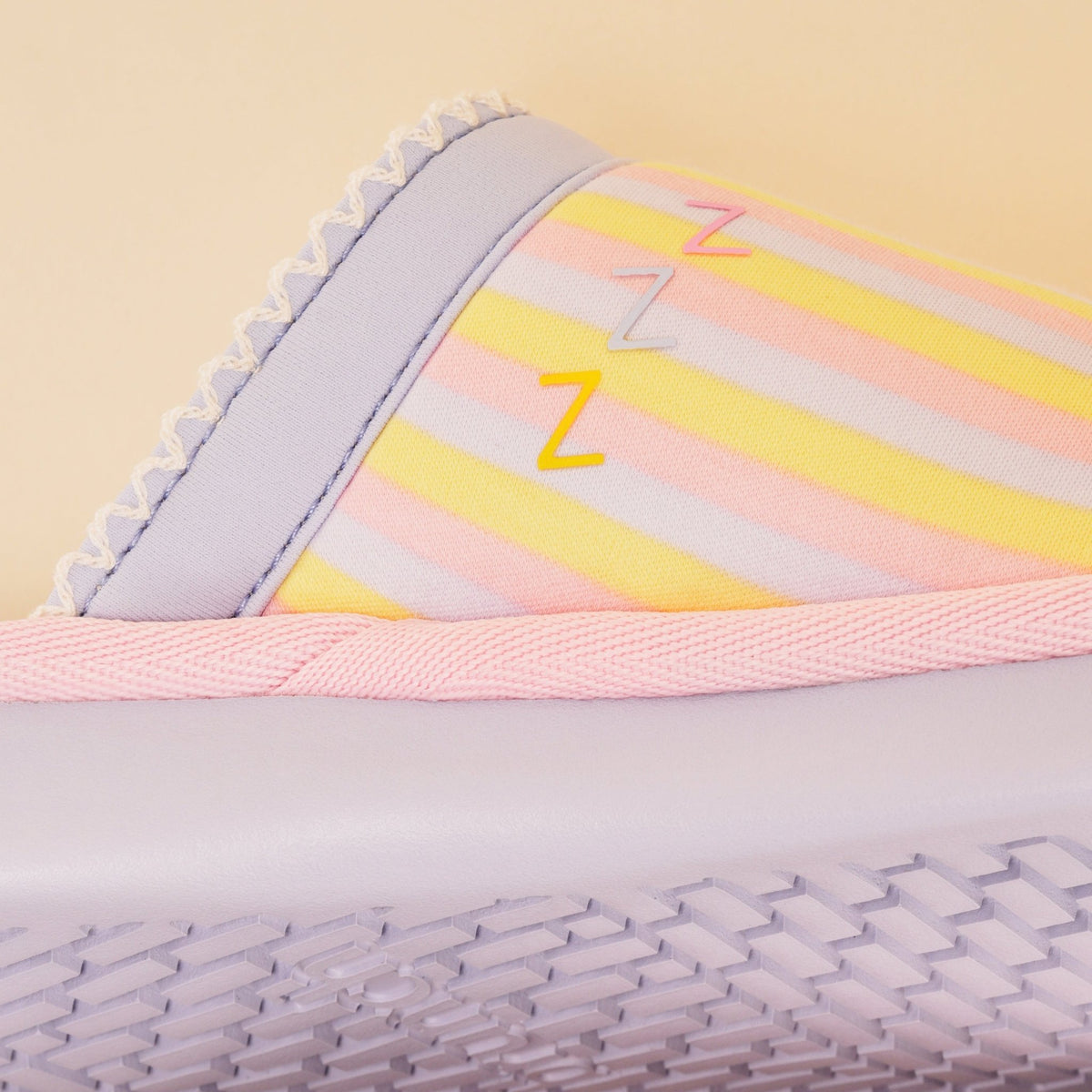 Close-up side view of Essential Rainbow slipper with pastel stripes, three Z accents, pink trim and lilac sole