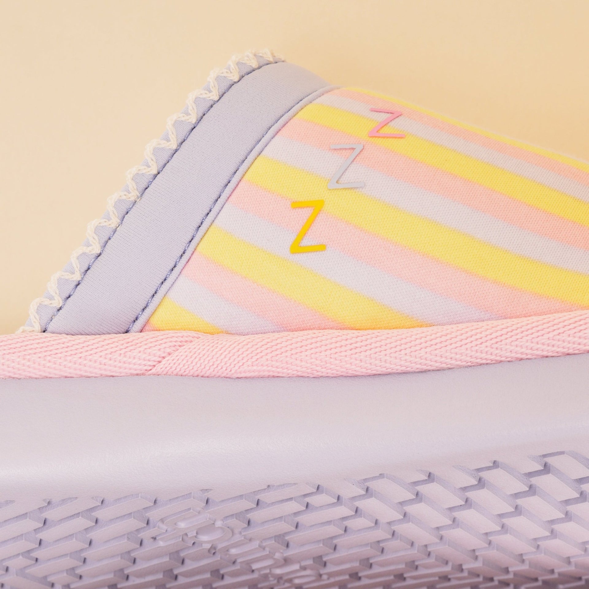 Close-up side view of Essential Rainbow slipper with pastel stripes, three Z accents, pink trim and lilac sole