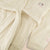 Close-up of Essential Robe in cream showing terry texture, hood, pocket and Hello Kitty embroidery on a neutral background