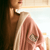 Close-up of model wearing pink Essential Robe showcasing embroidered Hello Kitty on the chest, hooded terry with cream trim