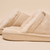 Close-up side view of Essential Shearling slipper showcasing beige suede upper, plush shearling lining, and embossed Brunch sole with neutral beige background