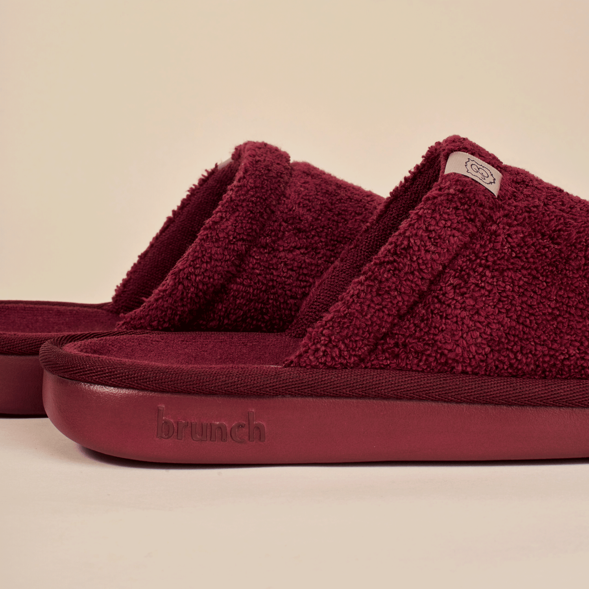 Close up side view of Essential slipper in burgundy showing terry loop upper and cushioned sole embossed brunch logo