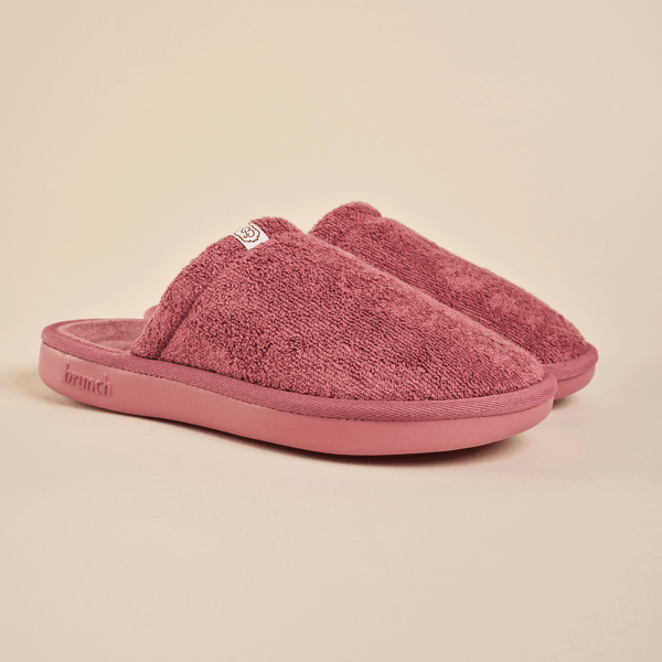 Three-quarter view of Essential Slipper in dusty rose terry cloth showcasing cushioned sole and open-back design on beige background