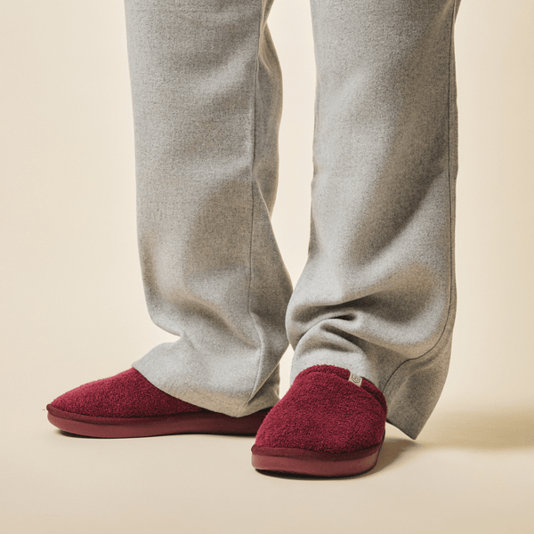 Close-up front view of Essential Slipper in burgundy showing terry-fabric upper and cushioned sole against beige studio background