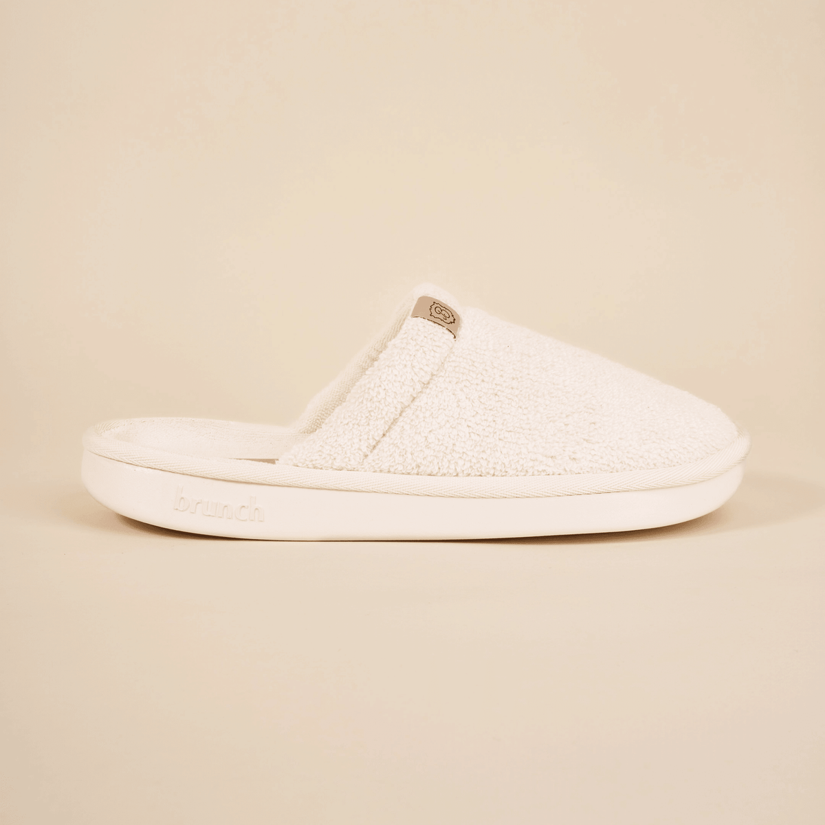 Side view of Essential Spring slipper with cream terry upper and cushioned sole embossed with brunch on neutral background