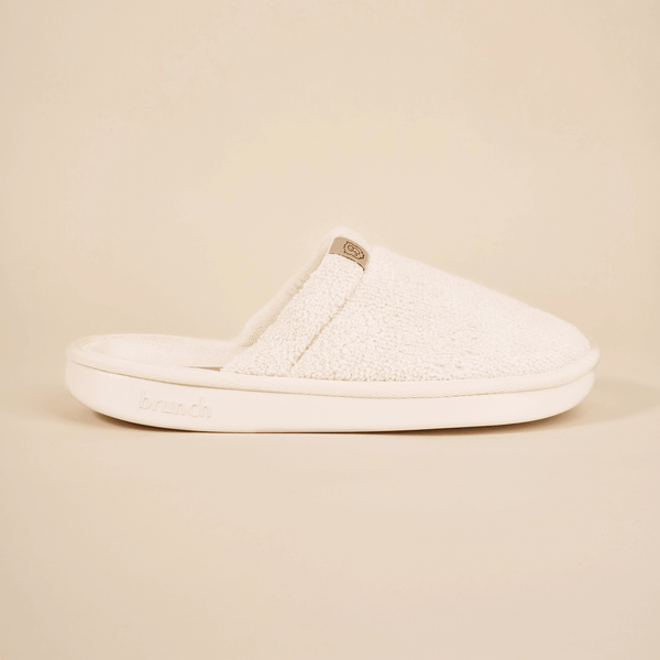 Side view of Essential Spring slipper with cream terry upper and cushioned sole embossed with brunch on neutral background