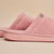 Close-up side view of pink Essential slipper showing terry-loop upper and cushioned sole with embossed brunch logo on pale beige background