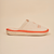 Side view of Essential The White Lotus slipper in beige showcasing linen upper, orange piping, and Brunch embossed EVA sole on neutral background