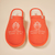 Top view of pair of orange White Lotus Essential slippers showing white embroidered 'THE WHITE LOTUS RESORT & SPA' logo and terry lining on a beige background
