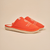 Three-quarter view of orange White Lotus slipper with embroidered White Lotus logo and EVA sole on beige background