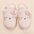 Top view of Essential XXL Hello Kitty slippers in cream terry showcasing 3D ears, pink knit bows, and embroidered whiskers on a cream background