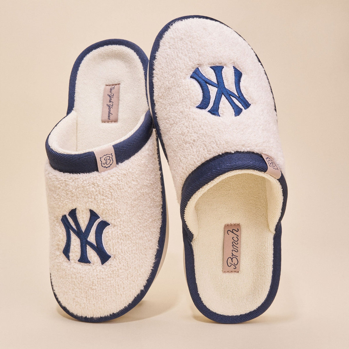 Top view of Essential Yankees cream terry slippers showcasing embroidered navy NY logo and navy trim on beige background