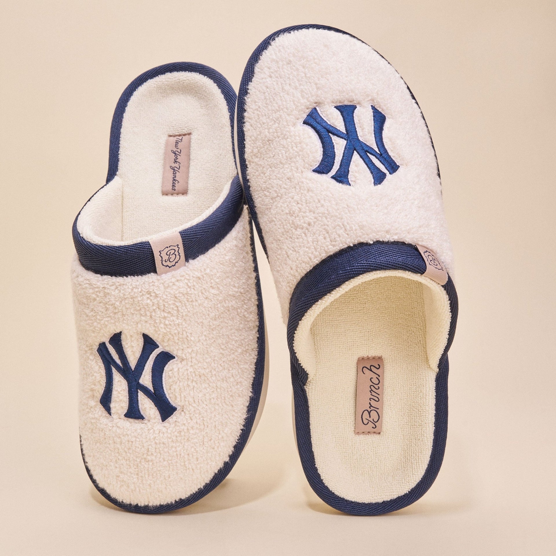 Top view of Essential Yankees cream terry slippers showcasing embroidered navy NY logo and navy trim on beige background