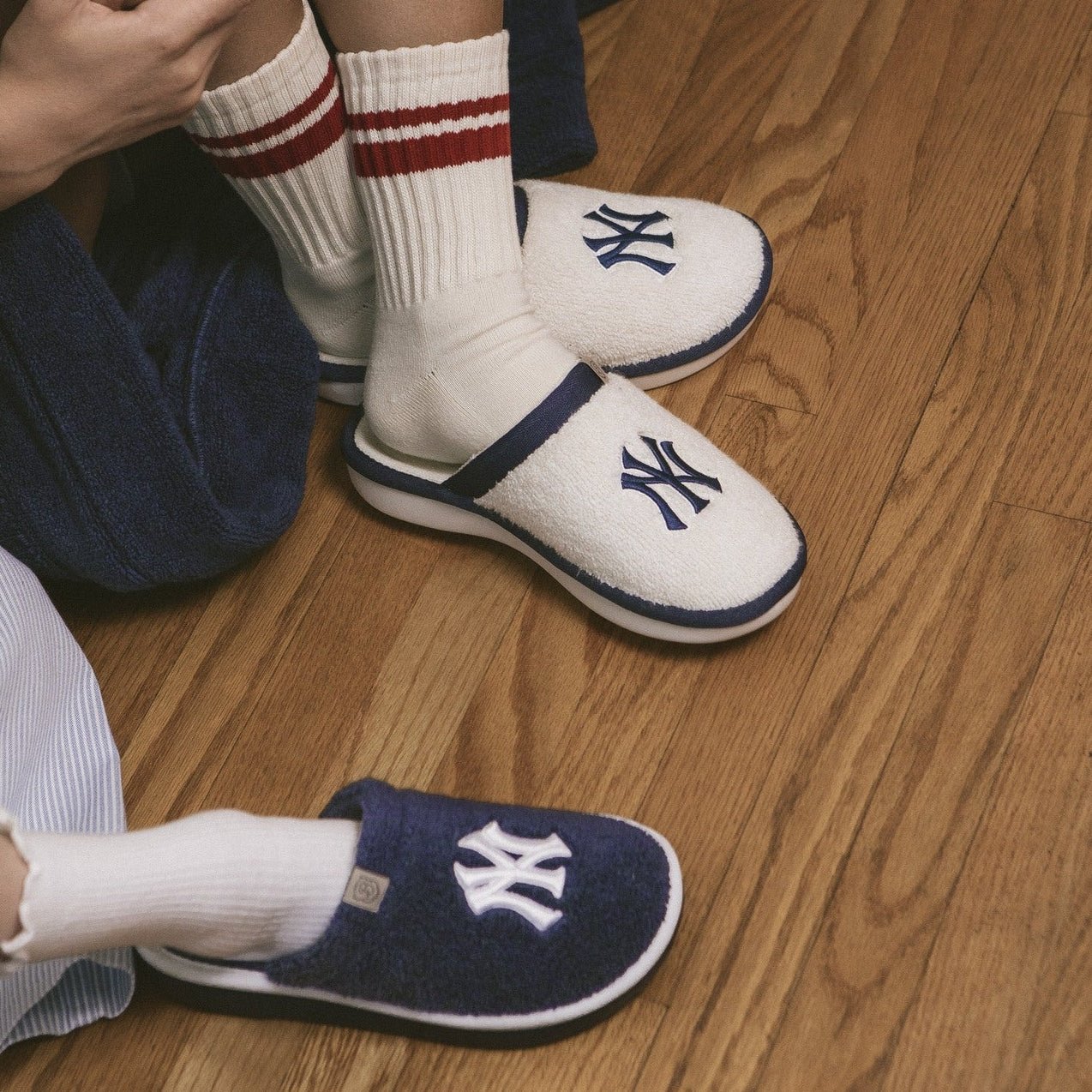 Three-quarter view of Essential Yankees cream terry slipper showing embroidered navy Yankees logo and navy trim on wood floor