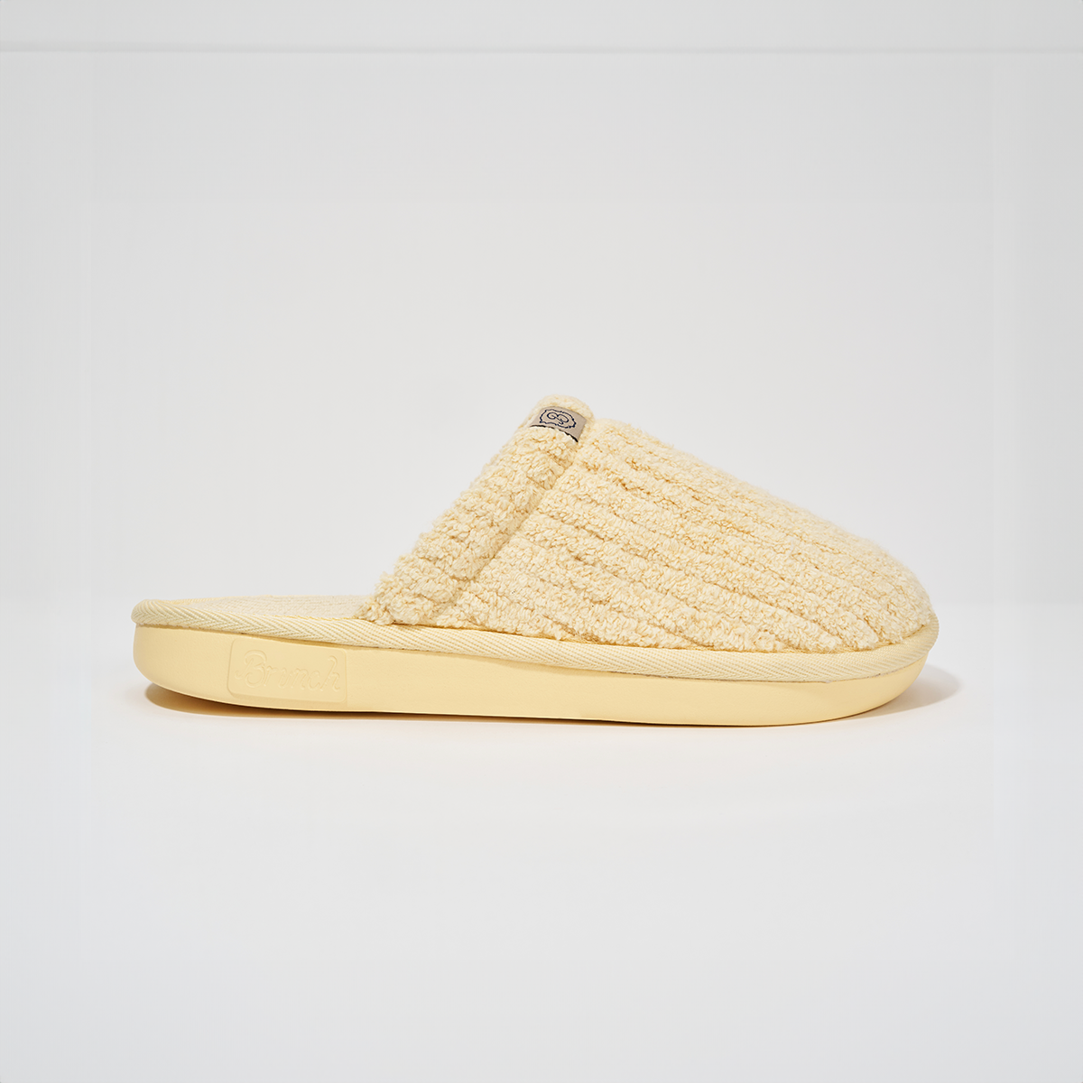 Side profile of Essential slipper in Limoncello ribbed terry showcasing ribbed texture and EVA outsole on white background