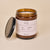 Three-quarter view of Holiday Candle in amber glass jar showcasing label fig&cedar 9oz with lid beside on beige background