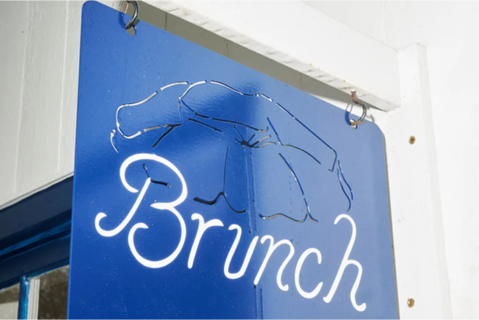 Blue hanging sign with cursive Brunch and umbrella outline