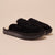 Front three-quarter view of Loafer Shearling in jet black suede showing shearling lining and slip-on back on beige background