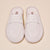 Top-down view of cream suede Yankees loafer showing embossed NY crest on vamp and penny strap on pale beige background