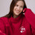 Close-up of Parke Mockneck in crimson on model showcasing mockneck collar and embroidered hearts with light background