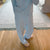 Front view of French Blue Cozyland pajama set with small pink print and relaxed wide-leg pants with button fly on hardwood floor