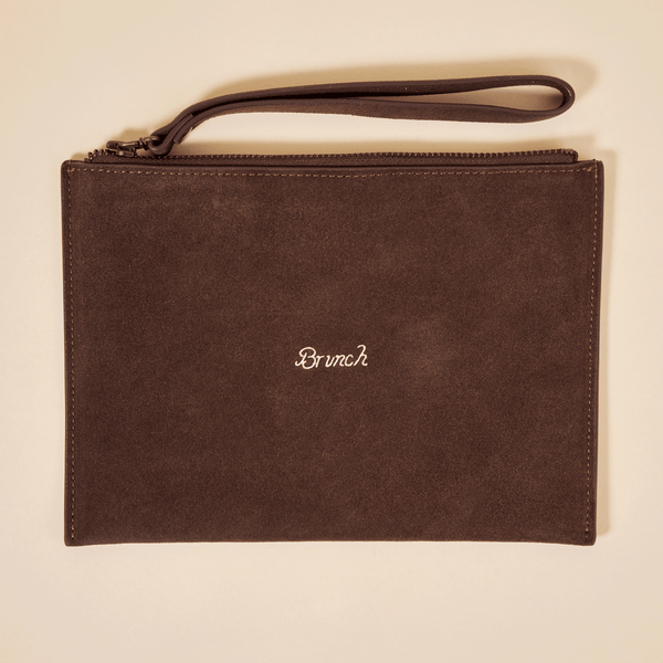 Top view of Brunch suede pouch in espresso brown showcasing embroidered Brunch logo, zip closure and wrist strap on a light beige background
