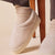 Side close-up of Puff XXL slipper in beige terry showing plush upper and thick platform sole on foot, cream background