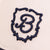 Close-up of Retro Crest cap front panel showcasing navy embroidered B crest on cream cotton fabric