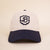 Front view of Retro Crest cap showcasing navy embroidered B crest and contrasting navy brim on cream cotton background