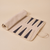 Angled top-down view of backgammon set opened to show beige suede interior with dark leather points on beige background