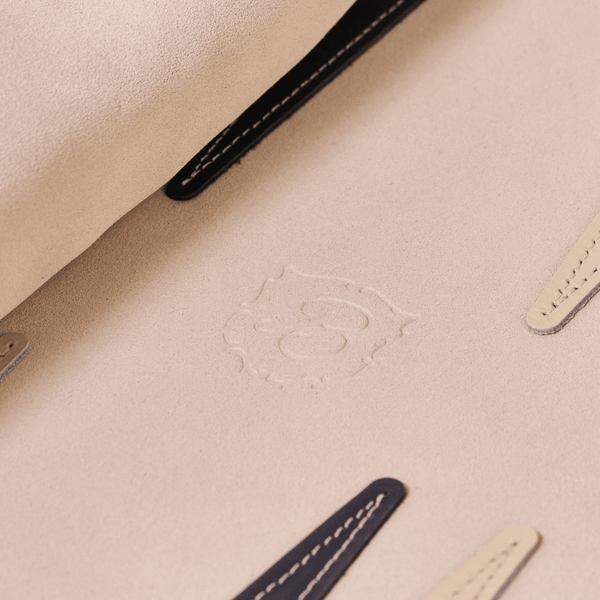 Close-up of Travel Backgammon Set interior showing beige suede texture, embossed Brunch logo, and stitched leather tabs