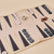 Angled view of Travel Backgammon Set unfolded showing beige suede interior, navy points, marbled checkers and dice on beige background