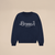 Flat-lay navy Varsity Crewneck in French terry with white embroidered Brunch script and small enjoy your stay text on beige