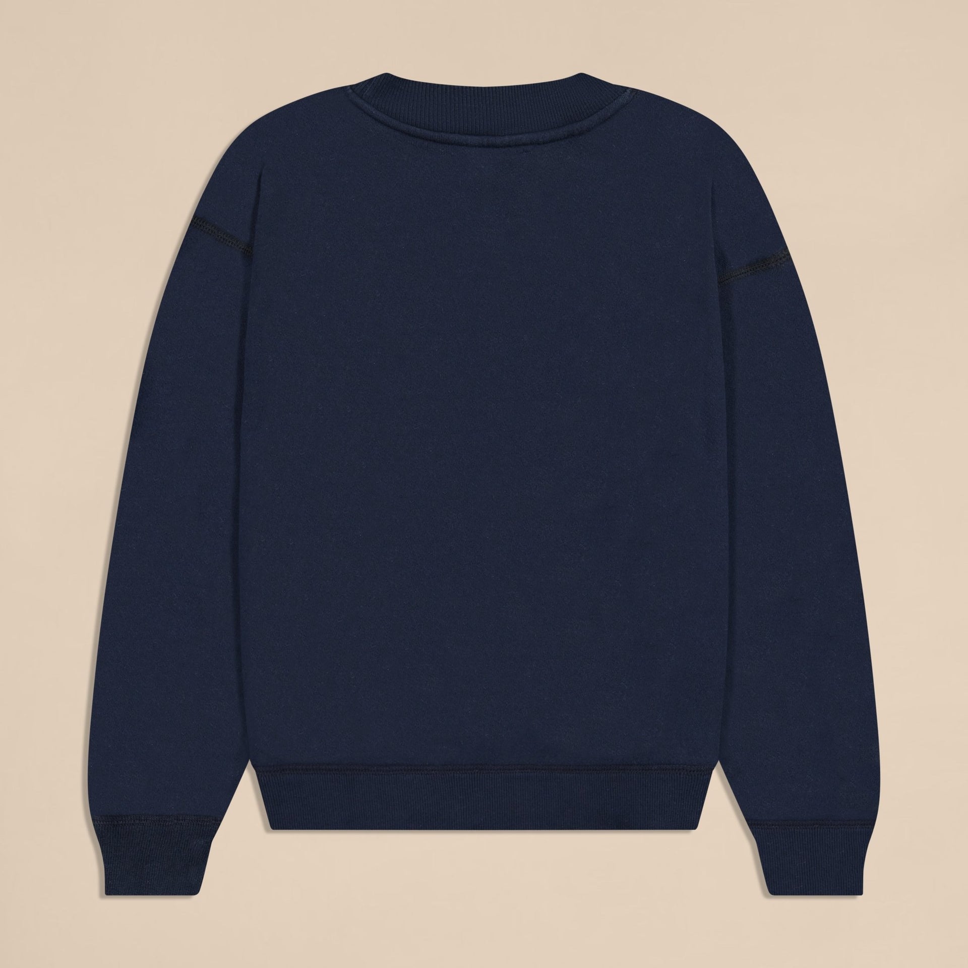 Back view of navy Varsity Crewneck in French terry showing ribbed neckline, cuffs, and hem on beige background