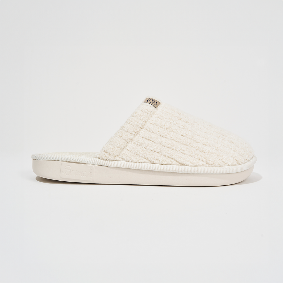Side view of Essential slipper showcasing ribbed terry upper and branded rubber sole on white background
